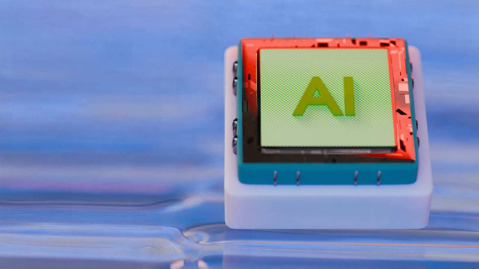 Images of a blue and red silicon microchip with the letters AI printed on the top, resting on a white cube.